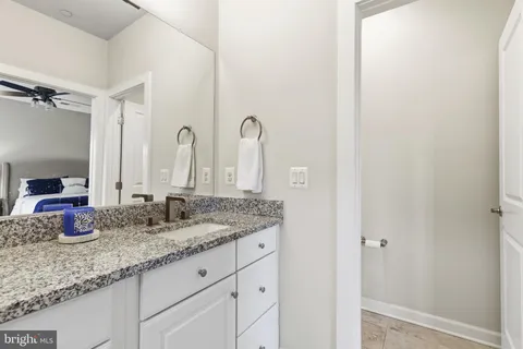 a bathroom with a granite countertop sink and a mirror