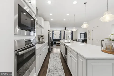 a large kitchen with stainless steel appliances kitchen island a large counter tops a stove a sink and a refrigerator