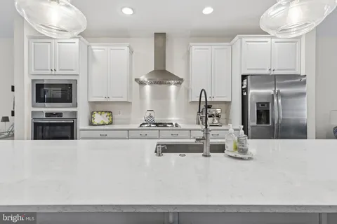 a kitchen with stainless steel appliances a sink a stove and a refrigerator