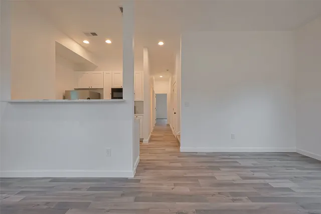 a view of a big room with wooden floor and windows
