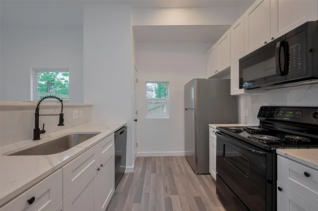 a kitchen with stainless steel appliances a stove microwave and sink