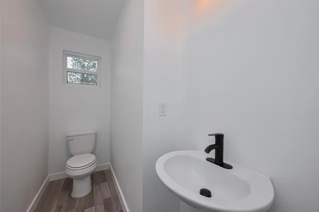 a bathroom with a toilet a sink and mirror