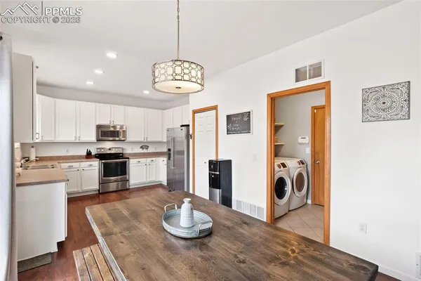 a kitchen with a refrigerator and a stove top oven