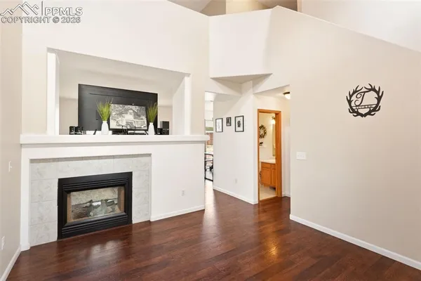 a view of a livingroom with wooden floor and a fireplace
