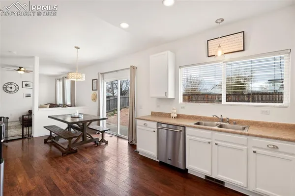 a view of a kitchen with stainless steel appliances granite countertop a stove and wooden floor