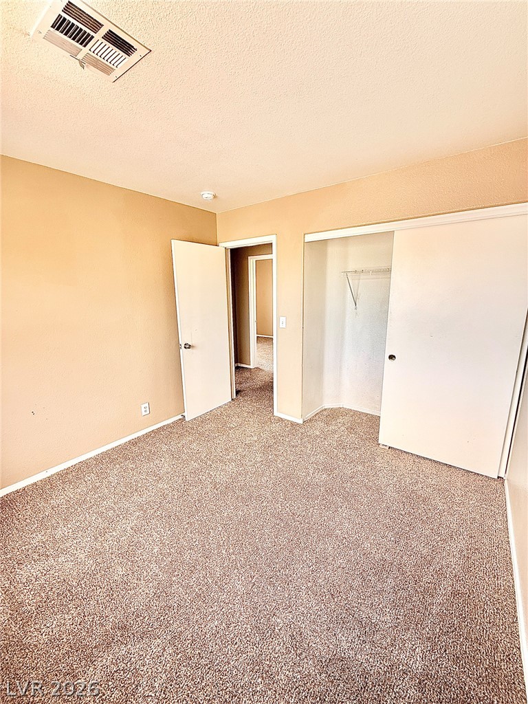 4313 Ranch Foreman Road North Las Vegas, NV 89032 - Photo 22 of 27 Warm-toned walls and classic carpeting define this comfortable bedroom complete with a built-in closet.