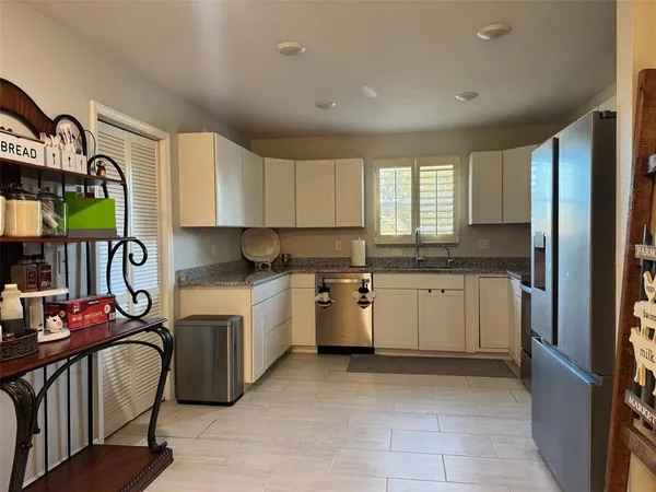 a kitchen with a sink window and cabinets