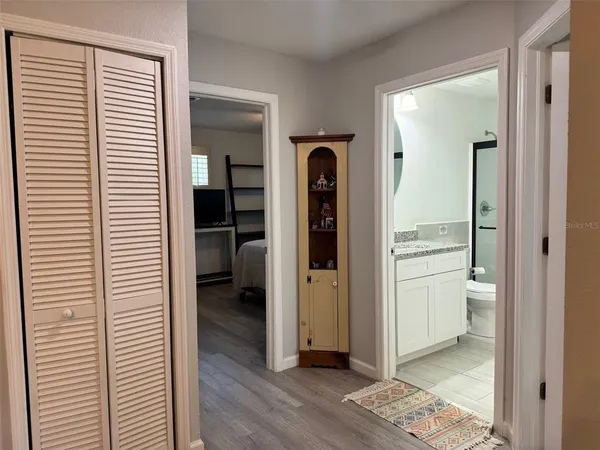 a view of a hallway with bathroom and wooden floor