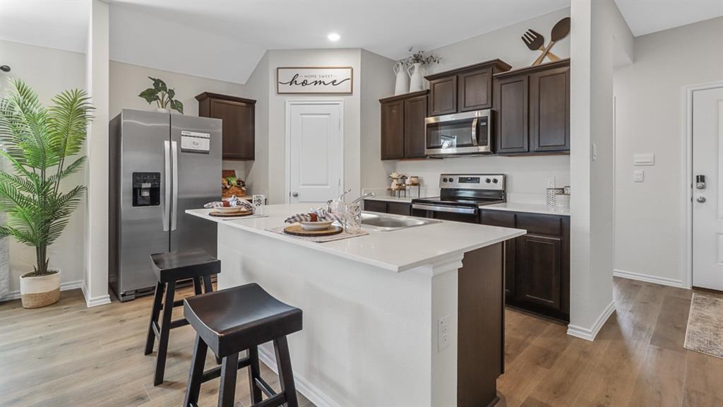 1667 Mantle Road Crandall, TX 75114 - Photo 6 of 20 Kitchen featuring an island with a white countertop and integrated sink