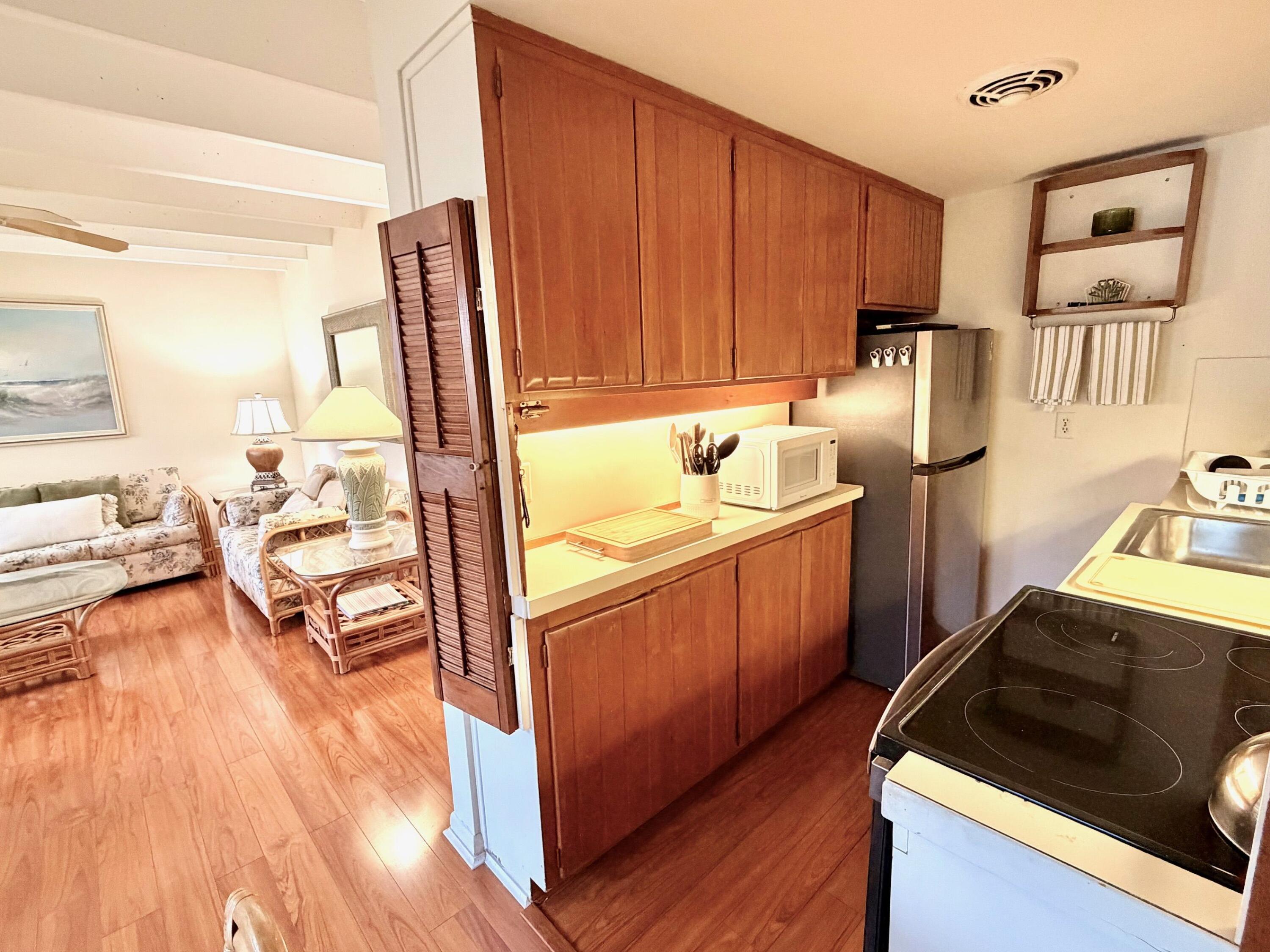 3500 South Ocean Boulevard, Unit 107 South Palm Beach, FL 33480 - Photo 20 of 24 a kitchen with stainless steel appliances granite countertop a sink stove and wooden cabinets