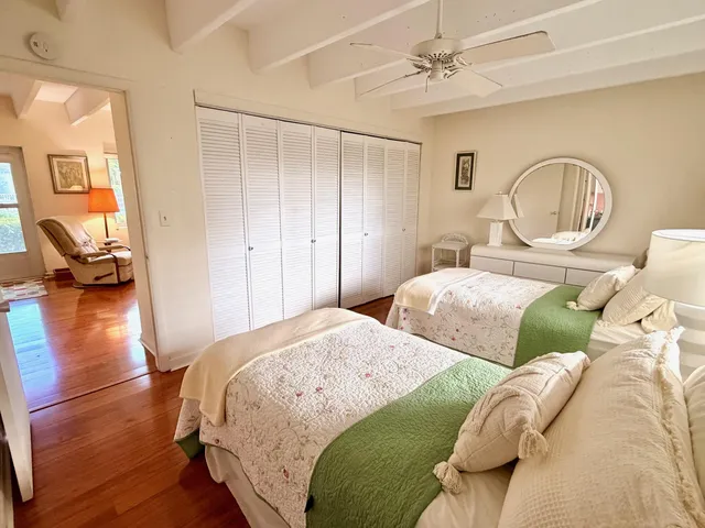 a bedroom with two beds and wooden floor