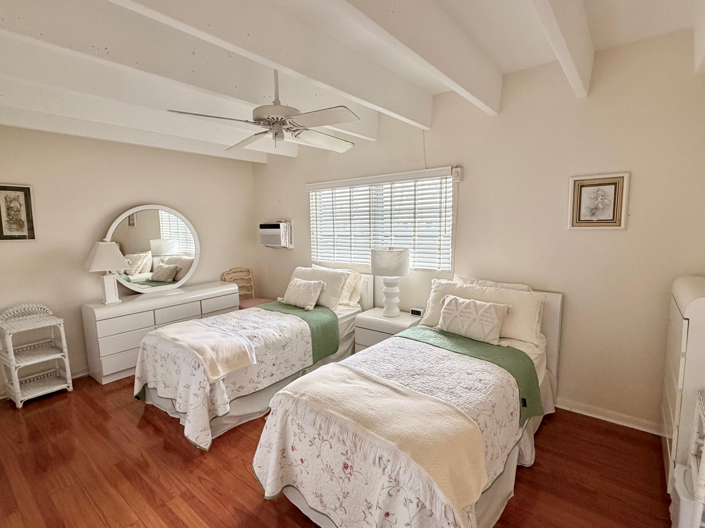 3500 South Ocean Boulevard, Unit 107 South Palm Beach, FL 33480 - Photo 24 of 24 a bedroom with two beds and a chandelier