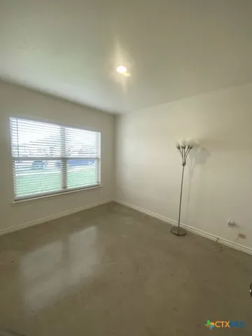 an empty room with chandelier fan