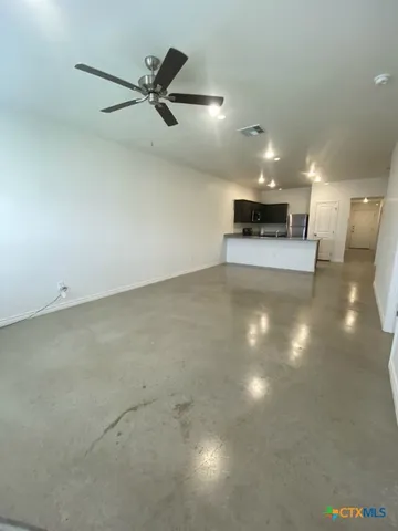 a view of a room with a ceiling fan and window