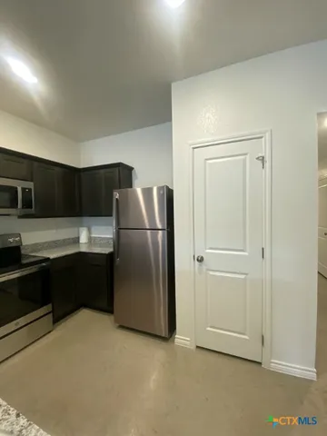 a kitchen with a refrigerator sink and cabinets