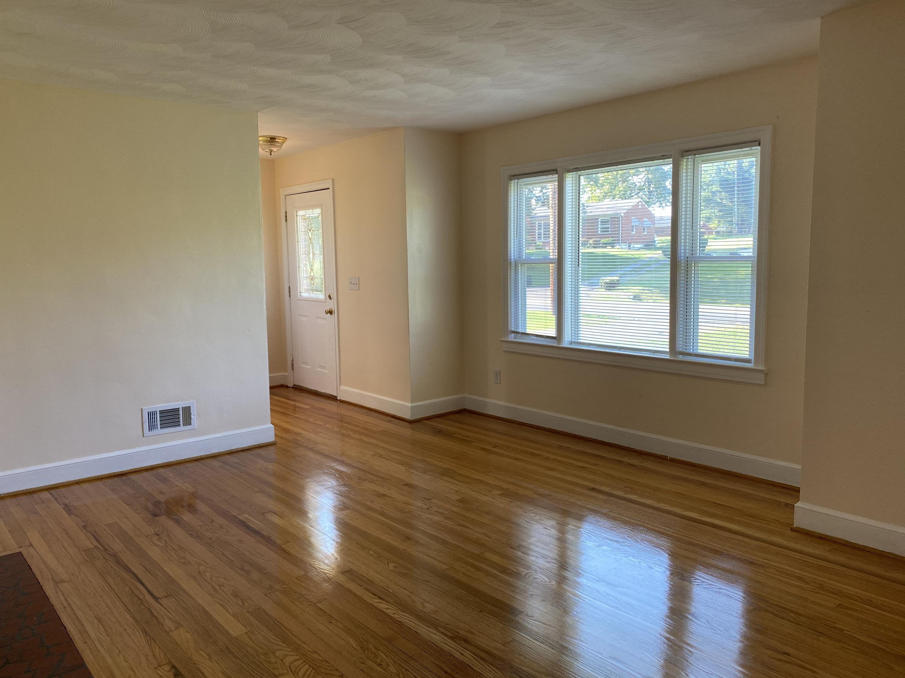 3731 Cove Road Roanoke, VA 24017 - Photo 5 of 25 a view of an empty room with wooden floor and a window
