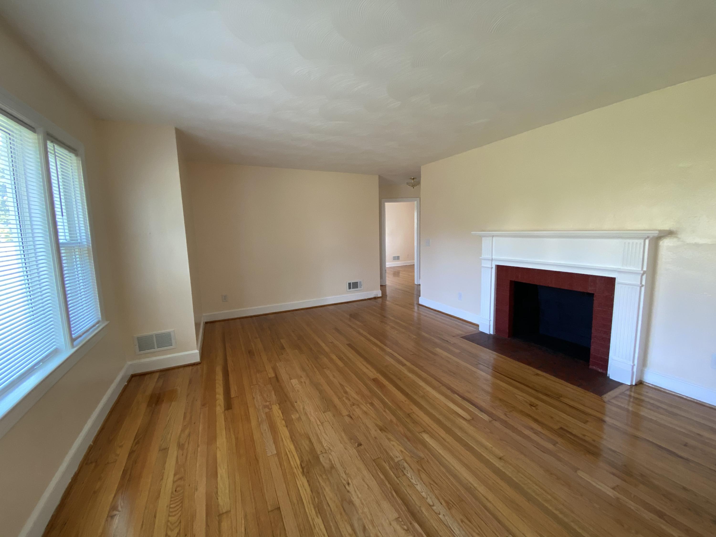 3731 Cove Road Roanoke, VA 24017 - Photo 7 of 25 wooden floor in an empty room with a fireplace