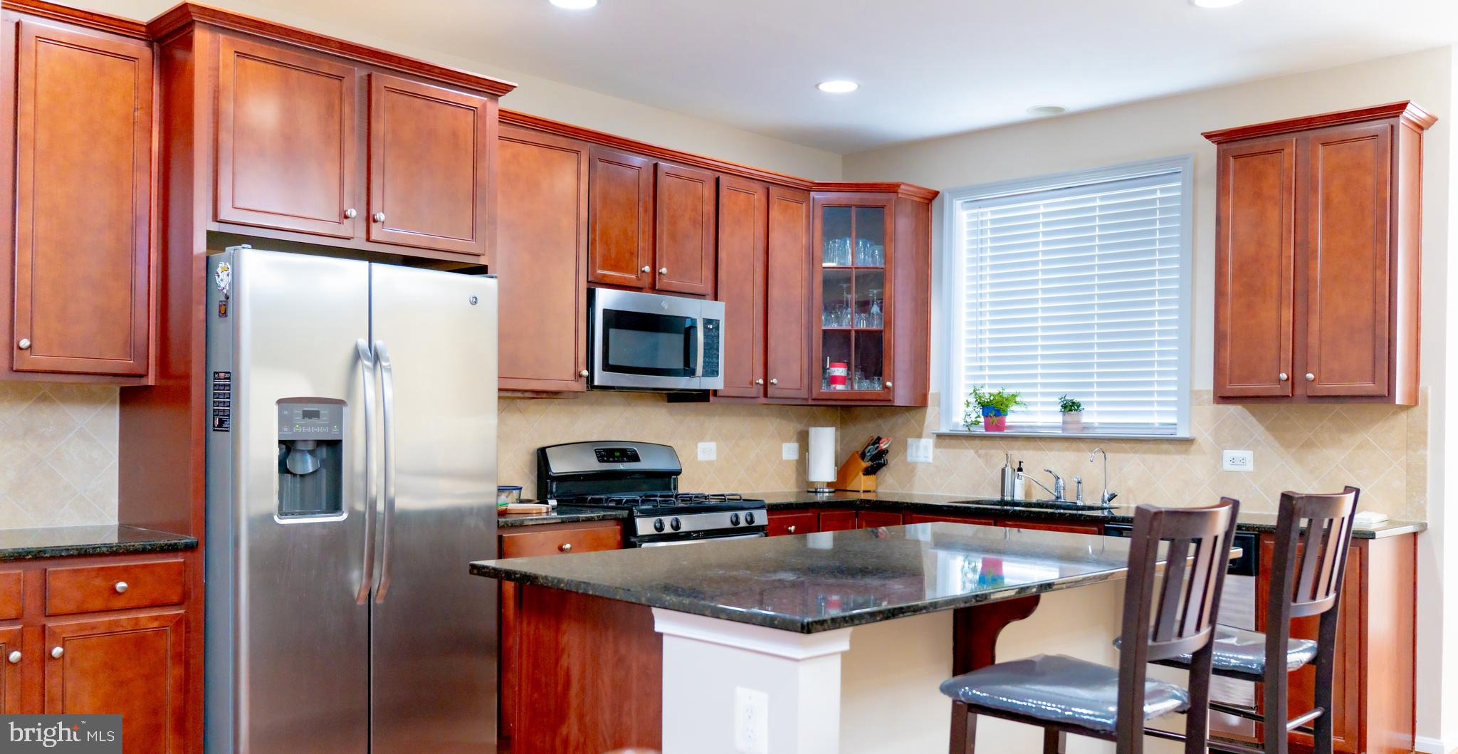 42258 Dean Chapel Square Chantilly, VA 20152 - Photo 7 of 35 a kitchen with stainless steel appliances granite countertop a refrigerator a stove top oven a sink and dishwasher