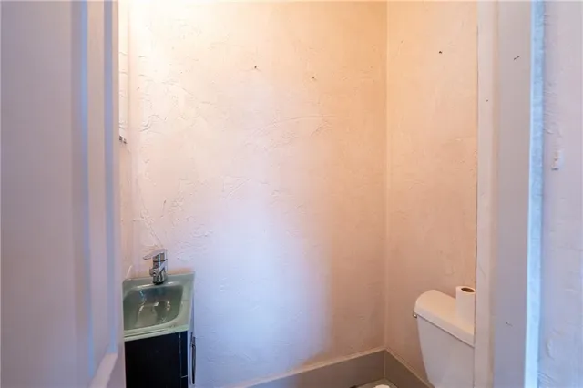 a bathroom with a granite countertop toilet and a sink