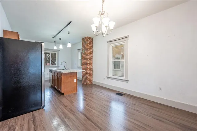 a view of a kitchen with a dishwasher a refrigerator and a fireplace