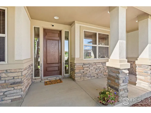 a dining room with furniture large windows and a chandelier