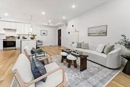 a living room with furniture and a view of kitchen
