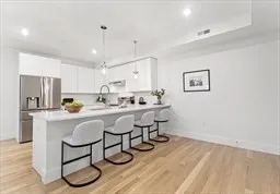 a kitchen with a sink cabinets and wooden floor