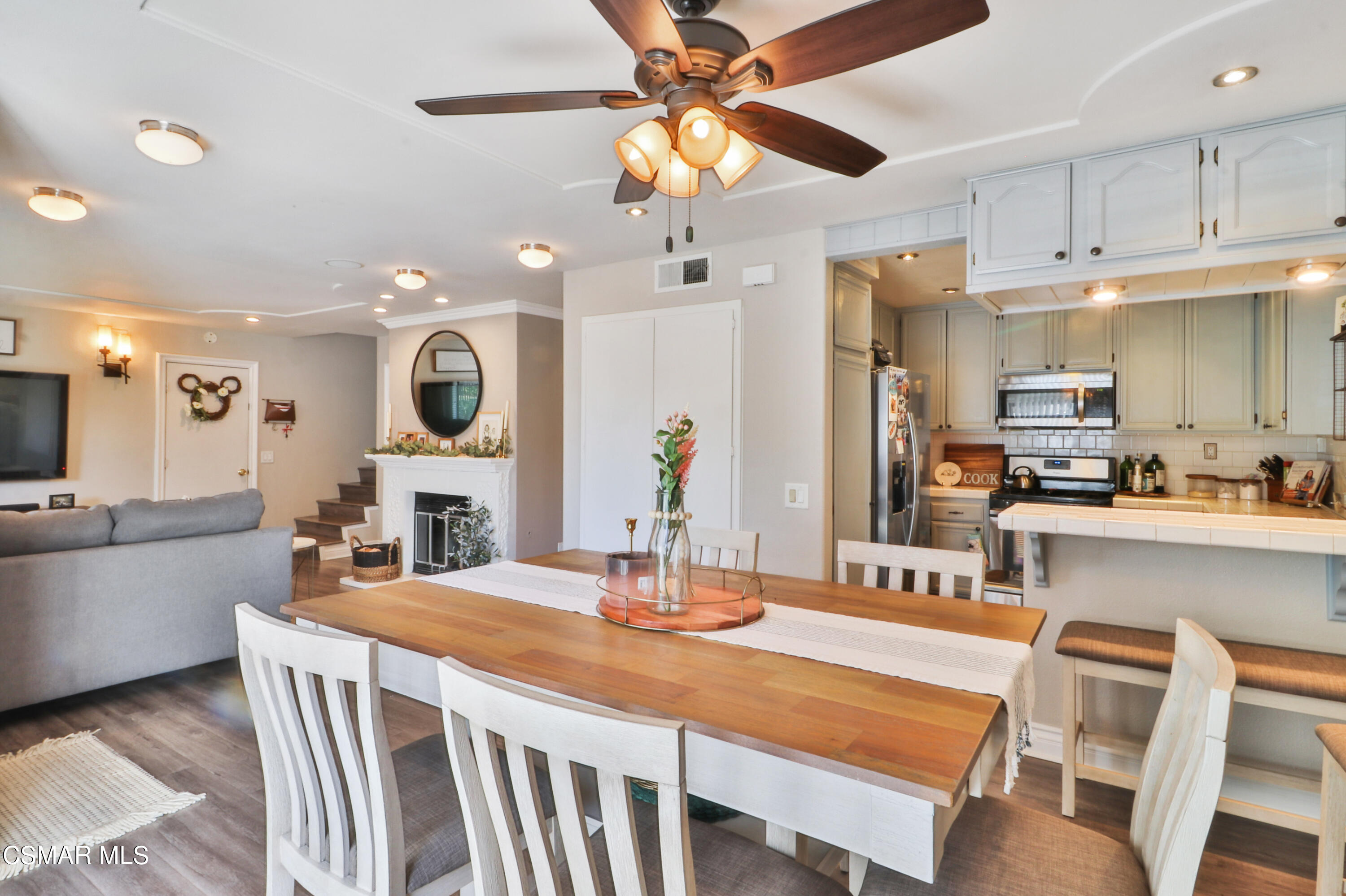 2346 Royal Avenue, Unit 9 Simi Valley, CA 93065 - Photo 14 of 31 a kitchen with stainless steel appliances kitchen island granite countertop a table chairs and a refrigerator