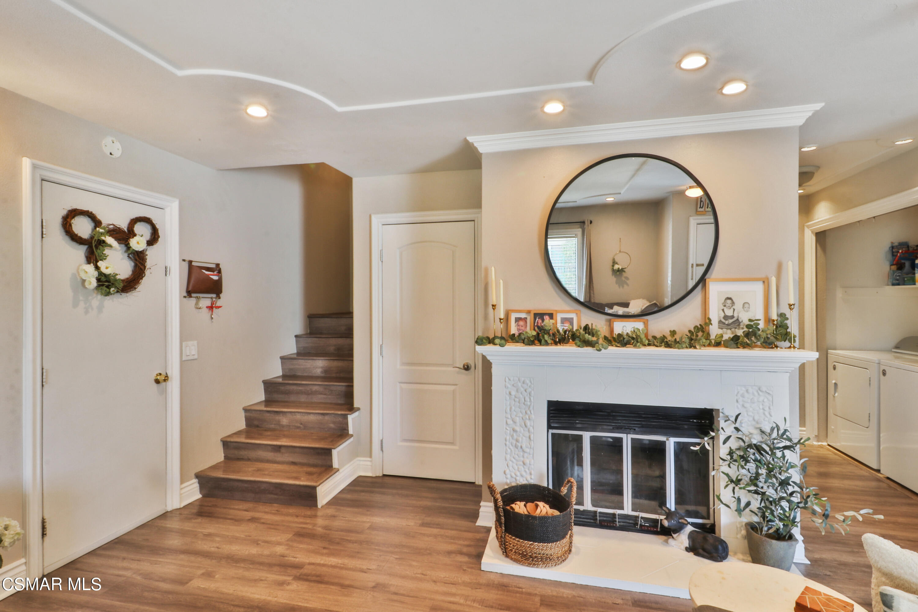 2346 Royal Avenue, Unit 9 Simi Valley, CA 93065 - Photo 10 of 31 a living room with a fireplace and a large mirror with wooden floor
