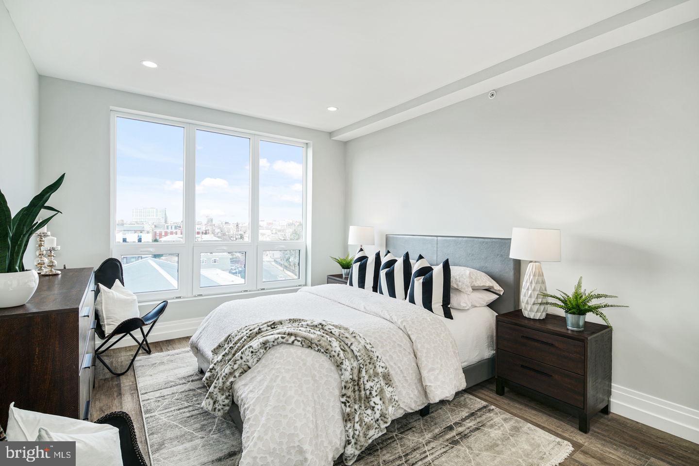 526 Brown Street, Unit 207 Philadelphia, PA 19123 - Photo 17 of 27 a spacious bedroom with a large bed and a potted plant