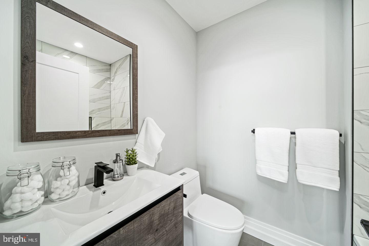 526 Brown Street, Unit 207 Philadelphia, PA 19123 - Photo 20 of 27 a bathroom with a sink vanity mirror and toilet