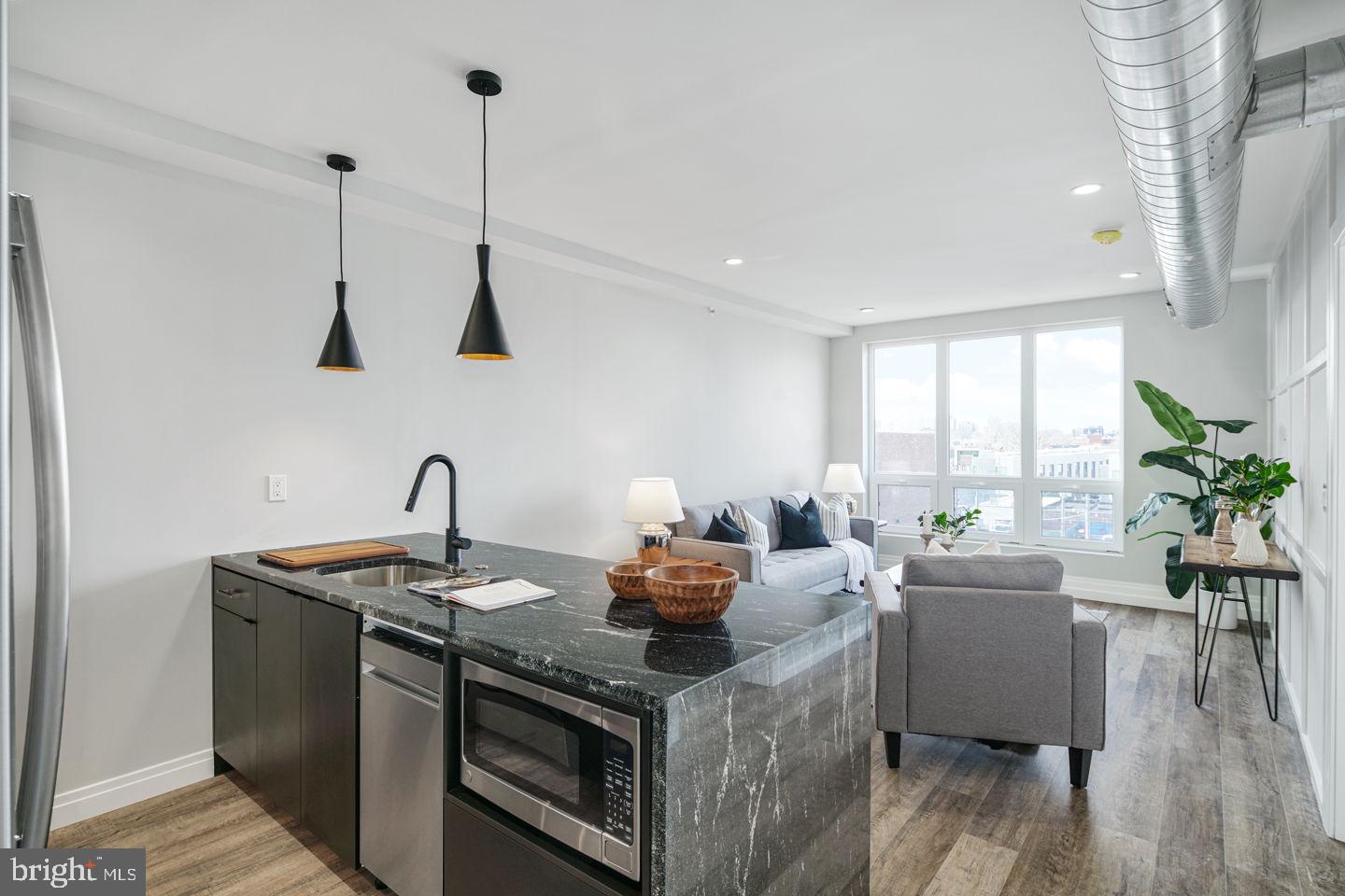 526 Brown Street, Unit 207 Philadelphia, PA 19123 - Photo 5 of 27 a kitchen with stainless steel appliances granite countertop a sink a stove and a wooden floors