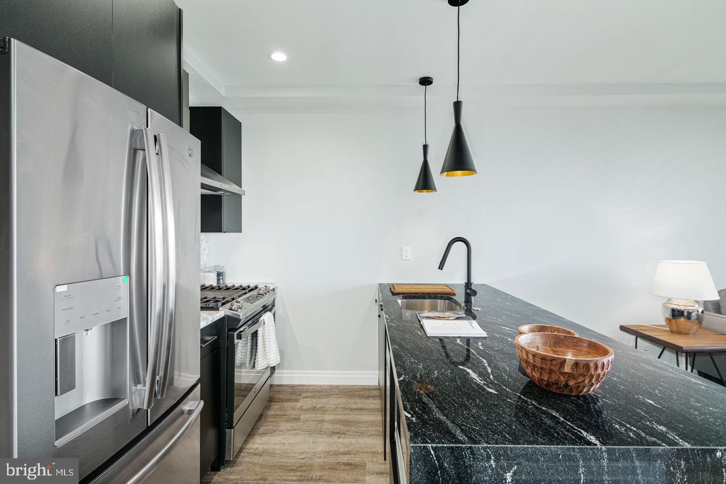 526 Brown Street, Unit 207 Philadelphia, PA 19123 - Photo 6 of 27 a kitchen with stainless steel appliances granite countertop a sink a stove and a refrigerator