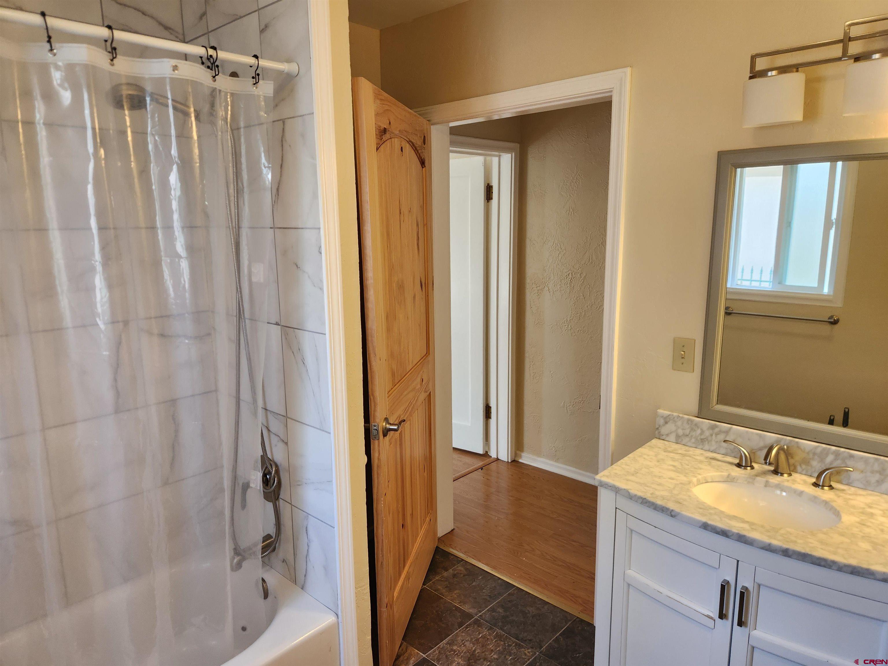 206 North Washington Street Cortez, CO 81321 - Photo 11 of 19 a bathroom with a granite countertop sink and a mirror