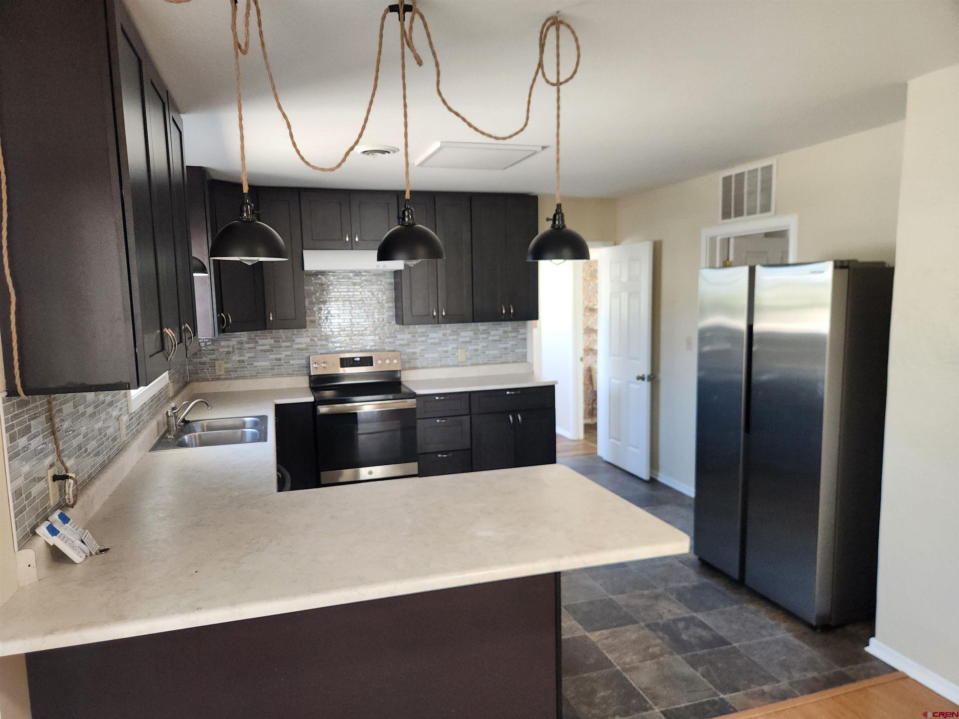 206 North Washington Street Cortez, CO 81321 - Photo 6 of 19 a kitchen with stainless steel appliances a sink a stove and refrigerator