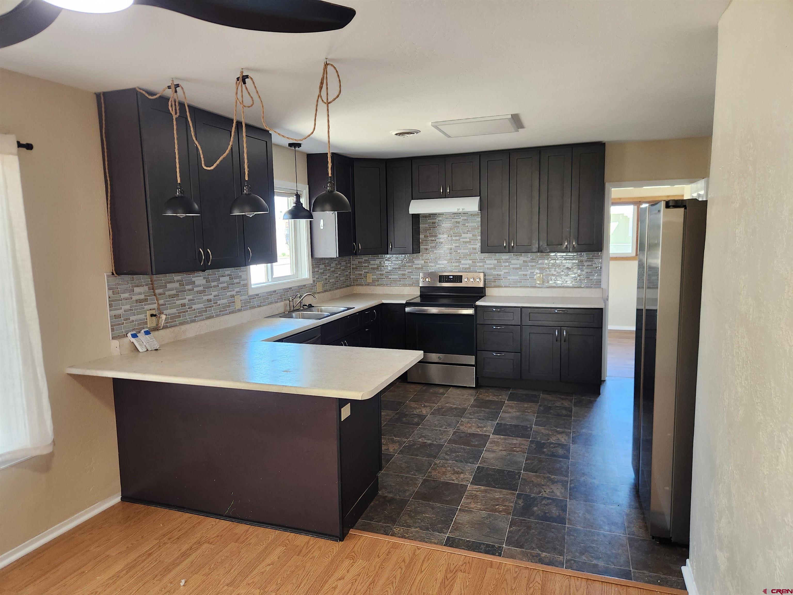 206 North Washington Street Cortez, CO 81321 - Photo 7 of 19 a kitchen with stainless steel appliances granite countertop a sink stove and refrigerator