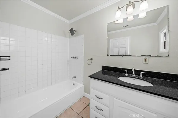 a bathroom with a bathtub a double vanity sink and mirror