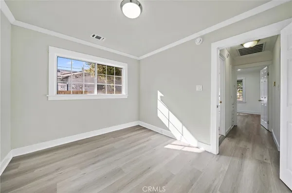 an empty room with wooden floor and a window
