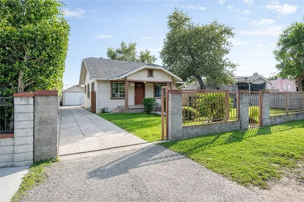 a front view of a house with a yard and potted plants