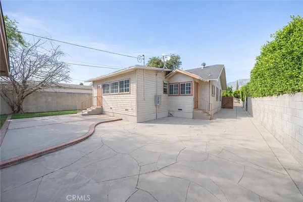 a view of a house with a yard and large tree