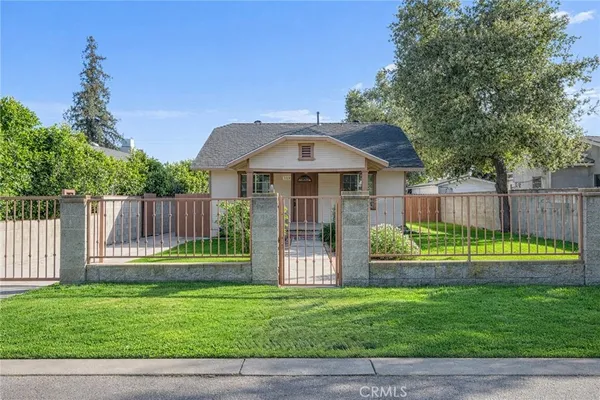 a front view of a house with a yard and trees