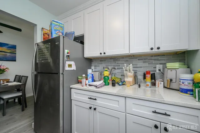 a kitchen with refrigerator and cabinets