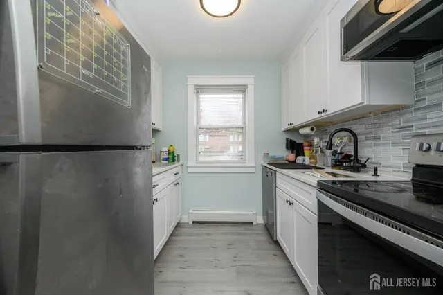 a kitchen with a refrigerator and a stove top oven