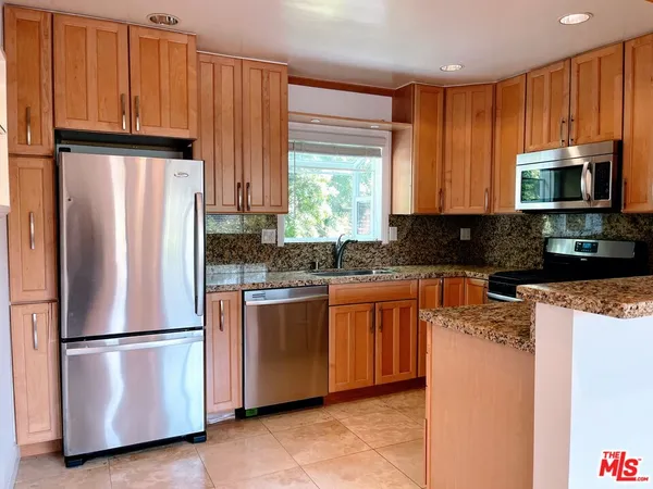 a kitchen with stainless steel appliances granite countertop a refrigerator stove a sink and dishwasher