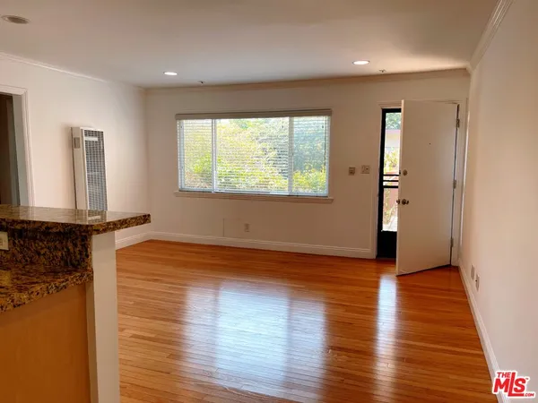 a view of a room with wooden floor and a window