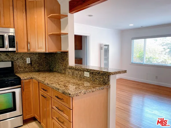 a kitchen with stainless steel appliances granite countertop a sink and a stove