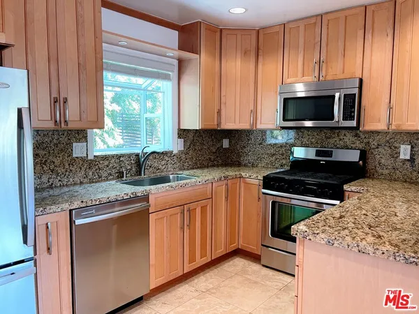 a kitchen with stainless steel appliances granite countertop a stove microwave and cabinets