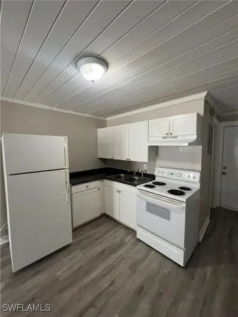 a kitchen with granite countertop white cabinets and white appliances