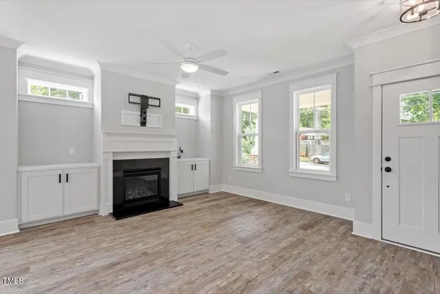 an empty room with windows and fireplace