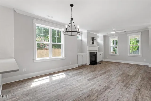 a view of empty room with wooden floor and fireplace